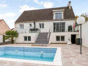 a house with a swimming pool in front of it at Grande villa T6 avec piscine à 30 min de Disneyland Paris in Coulommiers