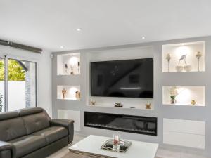 a living room with a couch and a flat screen tv at Grande villa T6 avec piscine à 30 min de Disneyland Paris in Coulommiers +32 photos