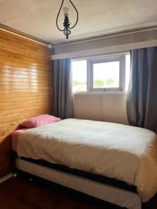 a bedroom with a large bed with a window at DEPARTAMENTO aV BULNES in Punta Arenas
