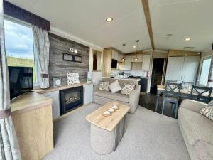 a living room with a couch and a tv and a fireplace at Rosies by the Sea in Walton-on-the-Naze