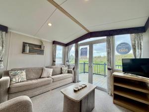 a living room with a couch and a tv at Rosies by the Sea in Walton-on-the-Naze