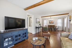 a living room with a large flat screen tv at Waldo Craftsman - Fenced yard Walkable to dining in Kansas City