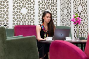 a woman sitting at a table with a laptop at The Suites in Antalya