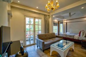 a living room with a couch and a table at Hotel Pajaros Blu in Calangute