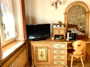 a wooden desk with a television on top of it at Garnì Stella Alpina in Canazei