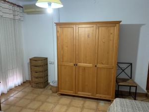 a bedroom with a wooden cabinet in a room at Can Llorach in Sant Jaume d'Enveja