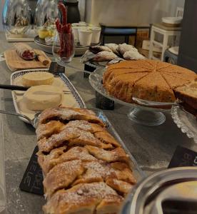a table with many different types of cakes and pies at Bed & Breakfast Cascina Beatrice in Rodello +24 photos