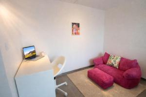 a living room with a red couch and a laptop at Le Candy- Appartement de charme à Digoin in Digoin