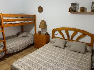 a bedroom with two beds and a bunk bed at Can Llorach in Sant Jaume d'Enveja