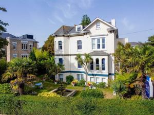 a white house with palm trees in front of it at No5 Durley Road in Bournemouth