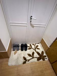 a pair of black shoes on a rug in front of a door at Уютная комната in Ganja