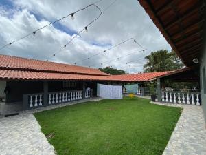 a house with a yard with a roof at Chácara recanto do Sagui in Santa Isabel
