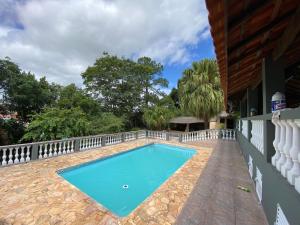 a swimming pool in a yard with a fence at Chácara recanto do Sagui in Santa Isabel