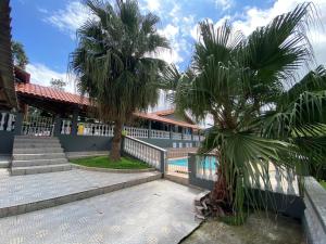 two palm trees in front of a building at Chácara recanto do Sagui in Santa Isabel