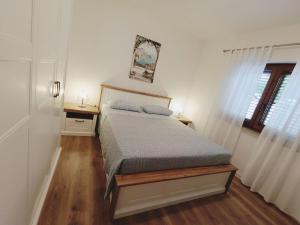 a small bedroom with a bed and a window at Apartment Vesna in Medulin