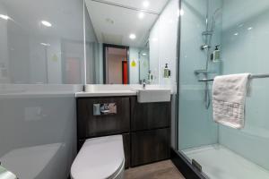 a bathroom with a shower and a toilet and a sink at easyHotel Cardiff in Cardiff