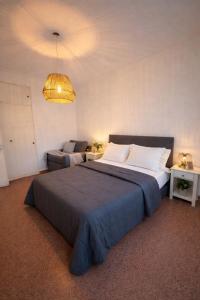 a bedroom with a large bed and a couch at Natullins Apartment in Ezeiza