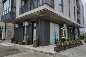 a building with potted plants in front of a store at Green Corner Kutaisi in Kutaisi