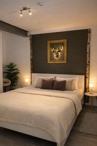 a bedroom with a large white bed with a black wall at Romantik 2-6P in Mürlenbach