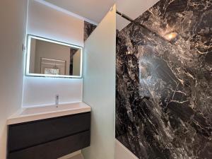 a bathroom with a sink and a mirror at maison Eglantine in Gréoux-les-Bains