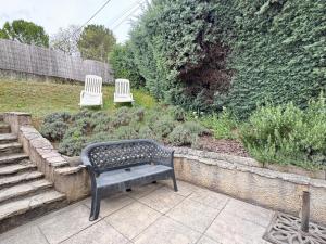 a bench sitting in a garden with two white chairs at maison Eglantine in Gréoux-les-Bains