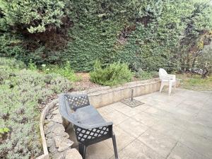 two chairs sitting on a patio next to a wall at maison Eglantine in Gréoux-les-Bains