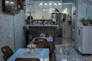 a dining room with two tables and a kitchen at Green Corner Kutaisi in Kutaisi