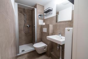 a bathroom with a shower and a toilet and a sink at FeWo mit Meerblick am Hansapark in Sierksdorf