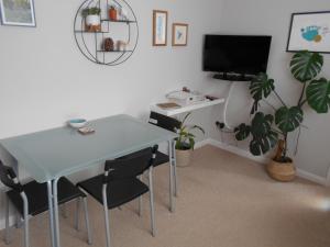 a dining room with a table and chairs and a tv at Acorns in Wavehorne