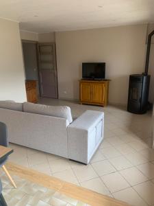 a living room with a couch and a tv at Gîte Les Vignes au Cheylard in Le Cheylard