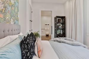 a bedroom with a white bed with pillows on it at Luxe 19BR Combo & Private Backyard with Pool in New Orleans