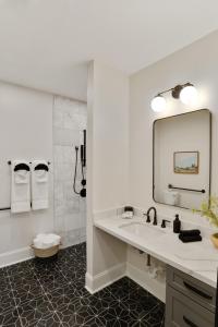 a white bathroom with a sink and a mirror at Luxe 19BR Combo & Private Backyard with Pool in New Orleans +108 photos