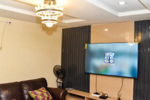 a living room with a couch and a flat screen tv at Skye Palace Apartment - Skye Regency 2 Bedroom Apartment in Akure