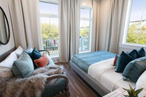 a bedroom with two beds and a couch and windows at 14BR Downtown Combo & Shared Seasonal Pool in New Orleans