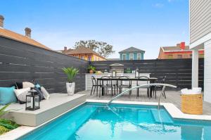 a backyard patio with a pool and a table and chairs at 14BR Downtown Combo & Shared Seasonal Pool in New Orleans +54 photos