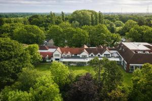 an aerial view of a mansion in the trees at Macdonald Craxton Wood Hotel & Spa, Chester in Ledsham