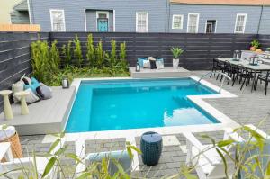 a swimming pool in a backyard with a table and chairs at 7BR City Condo & Pool Access Near CBD in New Orleans +30 photos