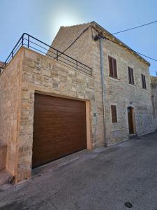 a large brick building with two garage doors at Stone house Anic in Vela Luka