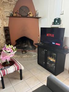 a living room with a tv and a fireplace at Friendly villagehouse in Paphos +16 photos