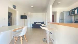 a kitchen and living room with a table and chairs at Bella Vista in Puerto Madryn