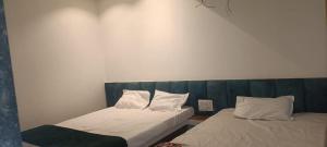 two beds sitting next to each other in a room at Chavan guest house in Akalkot +9 photos