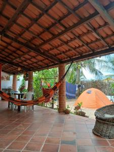 a hammock on a patio with a tent at Quarto Privativo e Camping em Canoa Quebrada in Canoa Quebrada