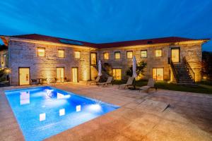 a house with a swimming pool in front of a building at Outeyro Retreat Country House in Marco de Canaveses
