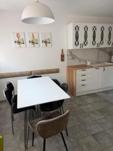 a kitchen with a white table and chairs at Rodzinna Przystań Arkadia in Dominice