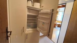 a kitchen with an open refrigerator with its door open at JÜRGEN Haus KMB Seeappartement am Ossiacher See, Hallenbad, Skiarena Gerlitzen in Bodensdorf +20 photos