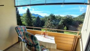 a balcony with a table and chairs and a large window at JÜRGEN Haus KMB Seeappartement am Ossiacher See, Hallenbad, Skiarena Gerlitzen in Bodensdorf