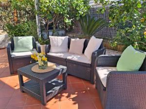 a patio with wicker chairs and a table with flowers at Casa Glicine in Sperlonga
