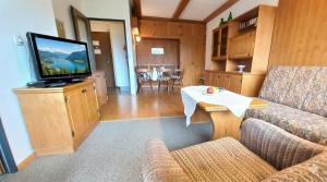 a living room with a couch and a flat screen tv at JÜRGEN Haus KMB Seeappartement am Ossiacher See, Hallenbad, Skiarena Gerlitzen in Bodensdorf