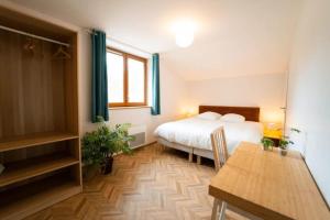 a bedroom with a bed and a table in it at L'Azimut in Senez