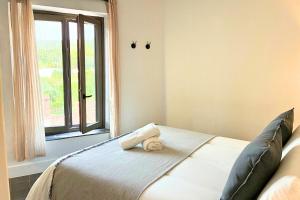 a bed with a teddy bear on it in a bedroom at Casa de Piedras by SIERRA VIVA desing in Cortelazor